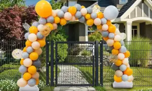 Jak samemu zrobić stojak na balony? Łuk z pomarańczowych, szarych i białych balonów nad bramką.