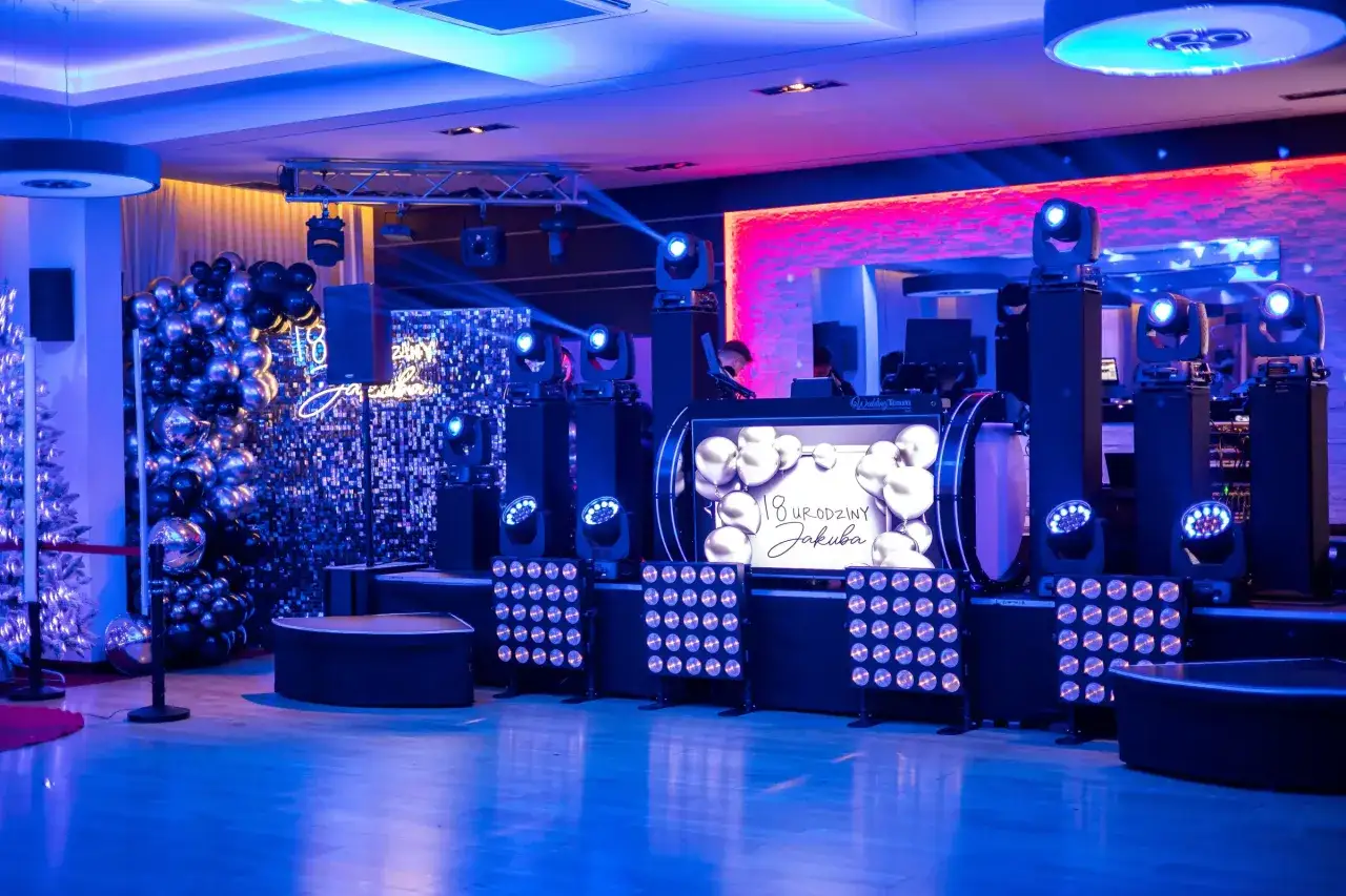 Efektowne atrakcje na 18 urodziny na sali: DJ, balony, światła i ekran z życzeniami.